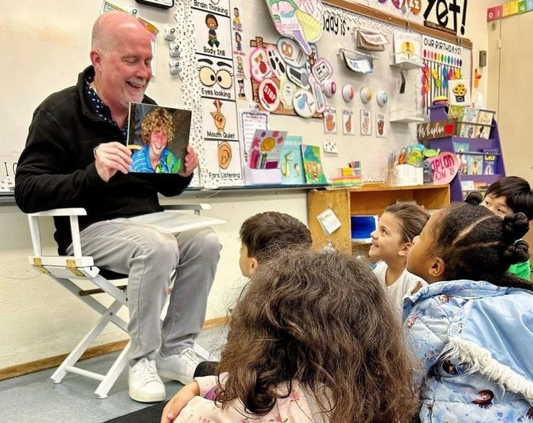 Joe McDonough shows a classroom of students a picture of Andrew during a school visit to raise awareness about childhood cancer and encourage kids to "be positive."