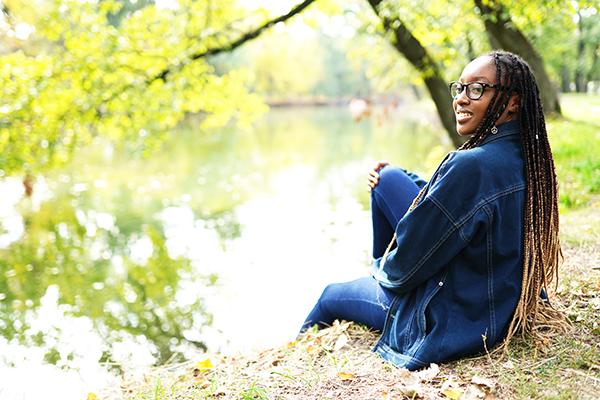 Woman sitting by a creek outside